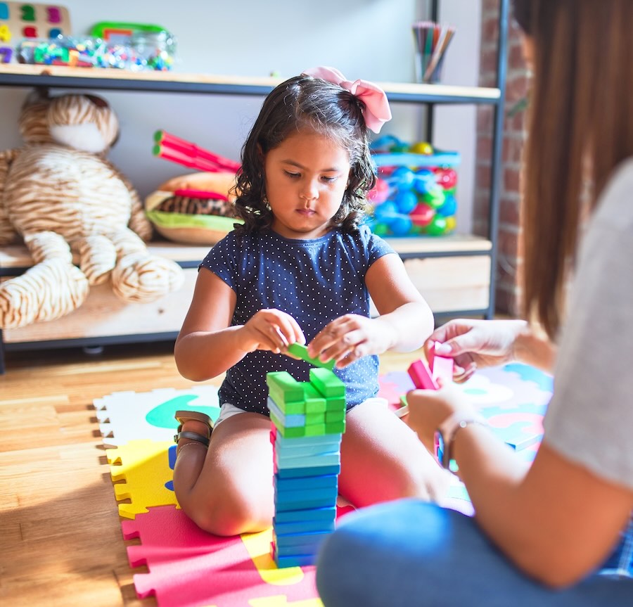 Woman observing child playing.